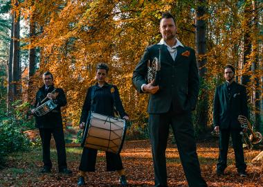 Members of Oi Musica pose in a forest